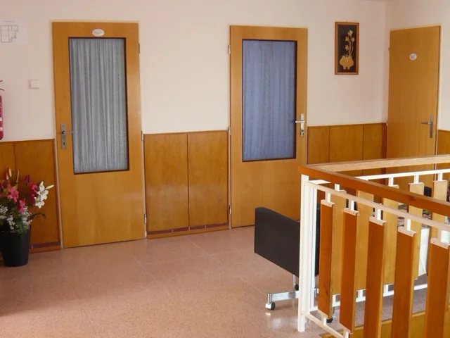 Hala v patře se schodištěm a dveřmi do pokojů