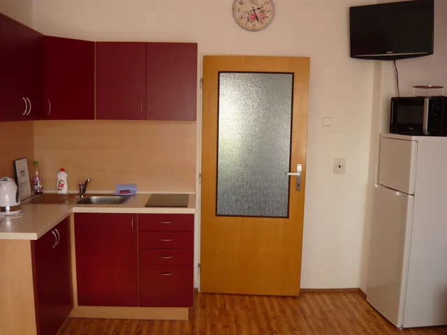 Červená kuchyňská linka, lednice a televize