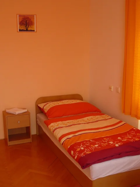 Samostatné lůžko v oranžově laděném pokoji